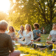 A group practicing mindfulness outdoors in a sunlit green setting, exuding calmness and positive mental well-being.